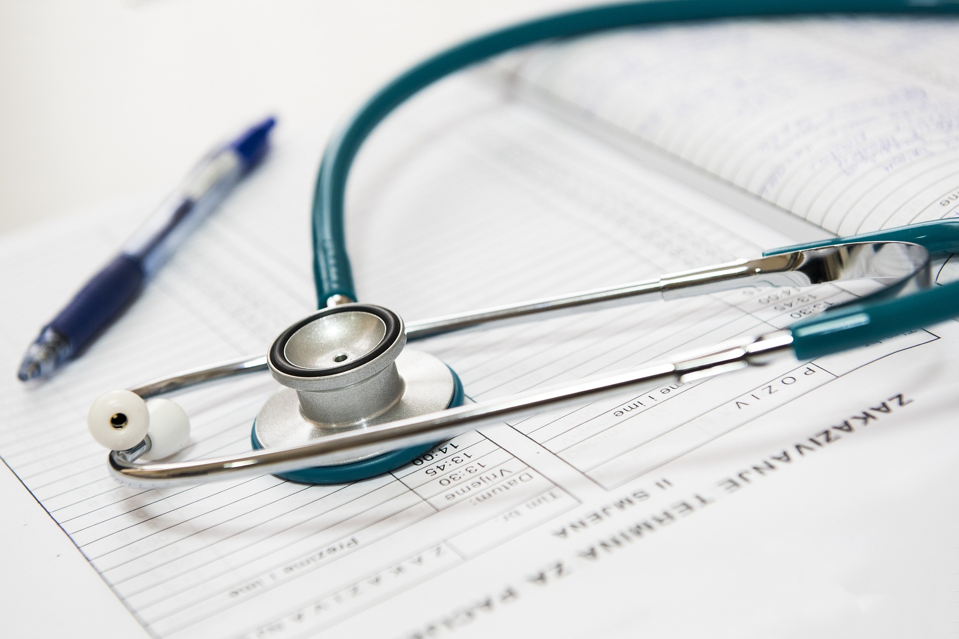 stethoscope lying on paper with pen