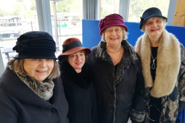 A selfie of four women, dressed in period costume
