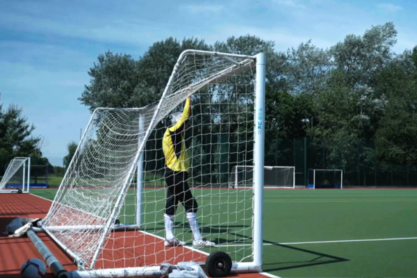 man in football gear standing in a goal