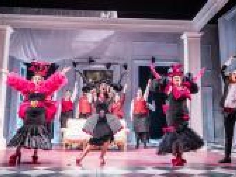 Photograph of a stage performance with performers dressed in red and black