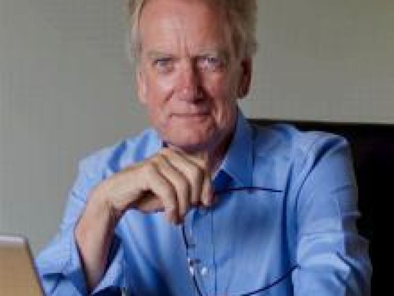 man in blue shirt in office chair with head on hand