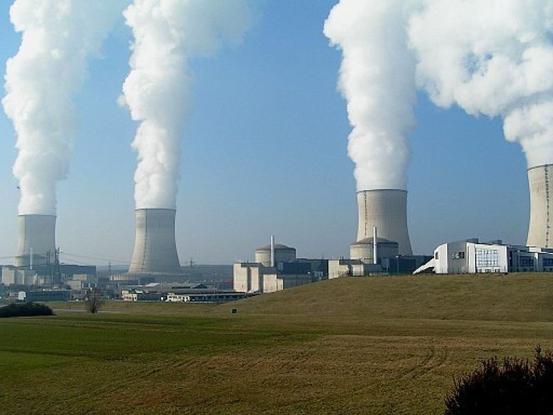 nuclear power station with plumes of white smoke against blue sky